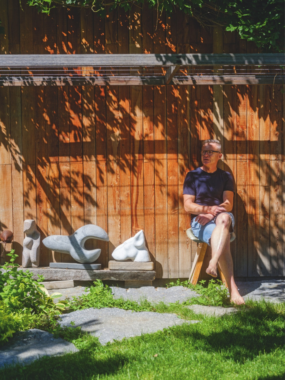 Cyril Hančl na zahradě svého domu se svými sochami
