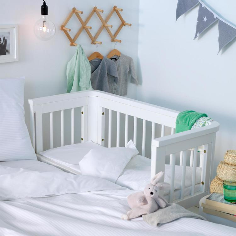 Přístavná postýlka má menší rozměry, ale pro novorozence je ideální – můžete mít dítě přímo u sebe a přitom si zachovat svůj prostor pro klidnější spánek. Foto: Minifabriken.com