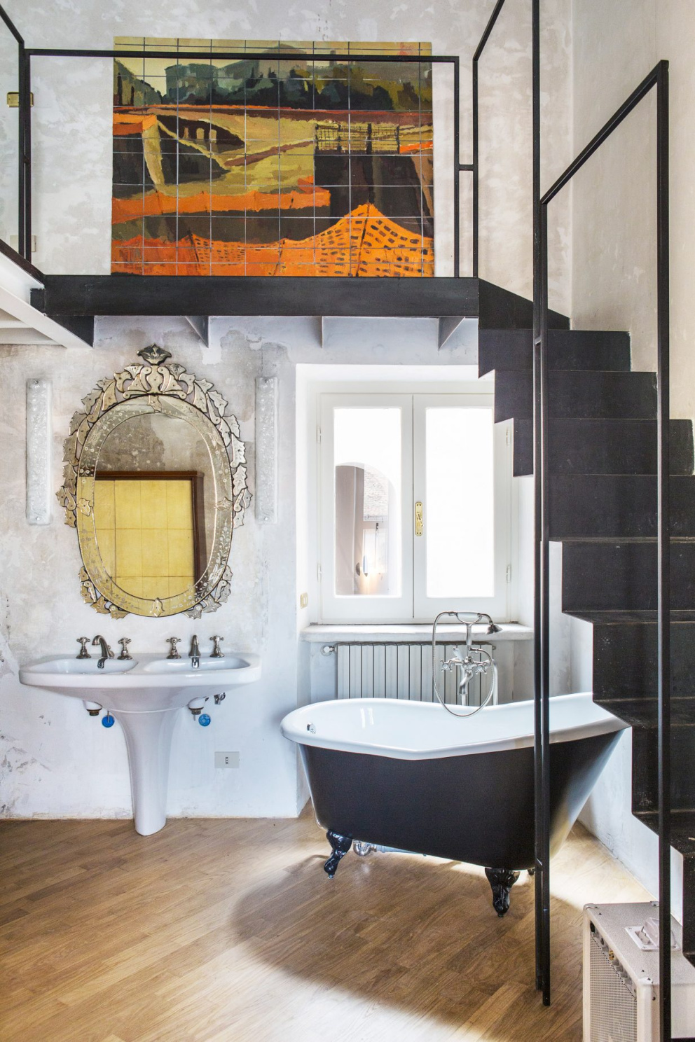 Koupelnu zdobí velké zrcadlo v ornamentálním rámu a secesní vana na nožičkách.