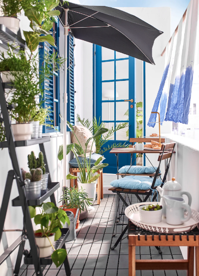 Barevnost tohoto balkonu vychází z modro-bílé kombinace, doplněné zelenými rostlinami a dřevěným nábytkem. 