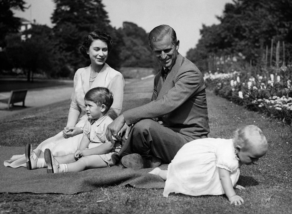 Královna Alžběta II. s princem Filipem a dětmi Charlesem a Anne v zahradě domu Clarence House v červenci 1951.
