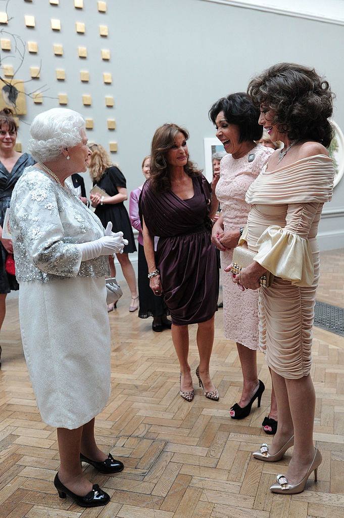 Herečka&nbsp;Joan Collins a zpěvačka&nbsp;Shirley Bassey oblékly na setkání s královnou v Royal Academy of Arts v roce 2012 světle růžové šaty v délce po kolena.
