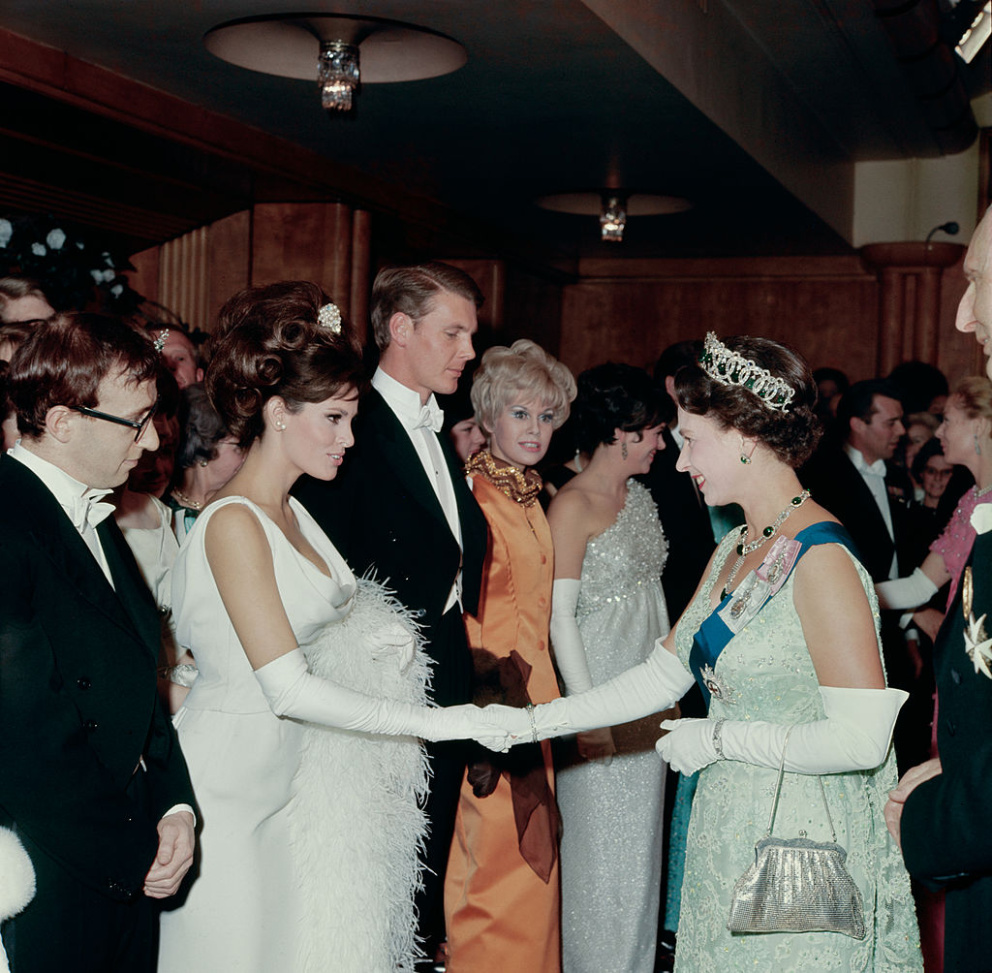 Americká herečka Raquel Welch se s britskou královnou setkala v roce 1966 při příležitosti Royal Variety Performance v Londýně. Zvolila bílé večerní šaty s rukavičkami.
