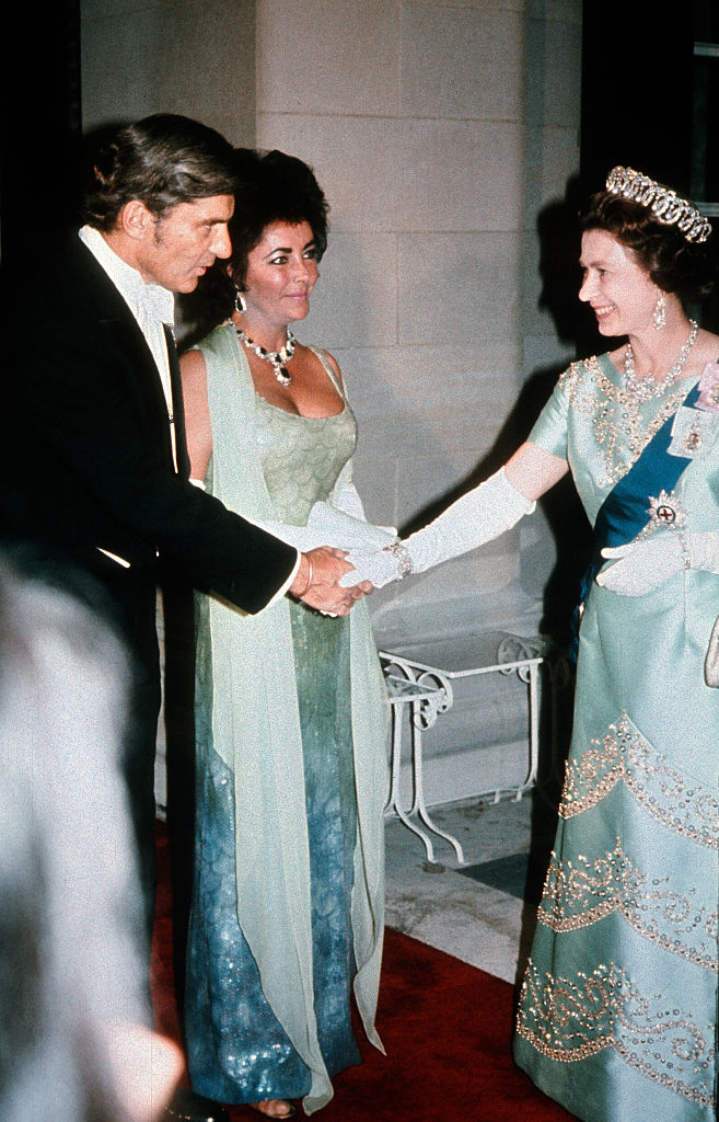 Herečka Elizabeth Taylor&nbsp;se s britskou královnou setkala v roce 1976 ve Washingtonu D.C. Na sobě měla modrozelenou róbu a výrazný náhrdelník.
