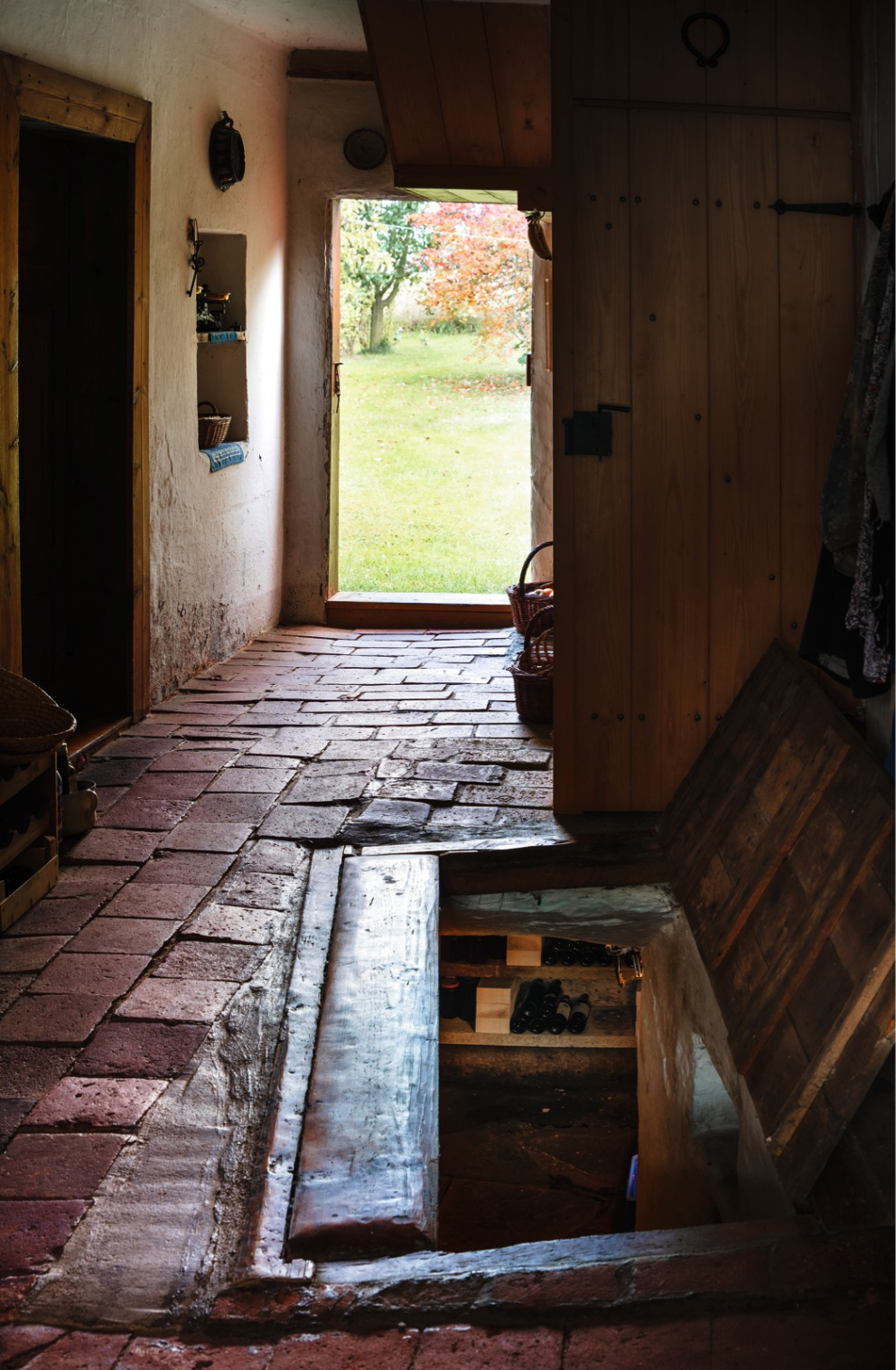 Do sklepa se vstupuje po odklopení dřevěné desky v podlaze průjezdu domu.