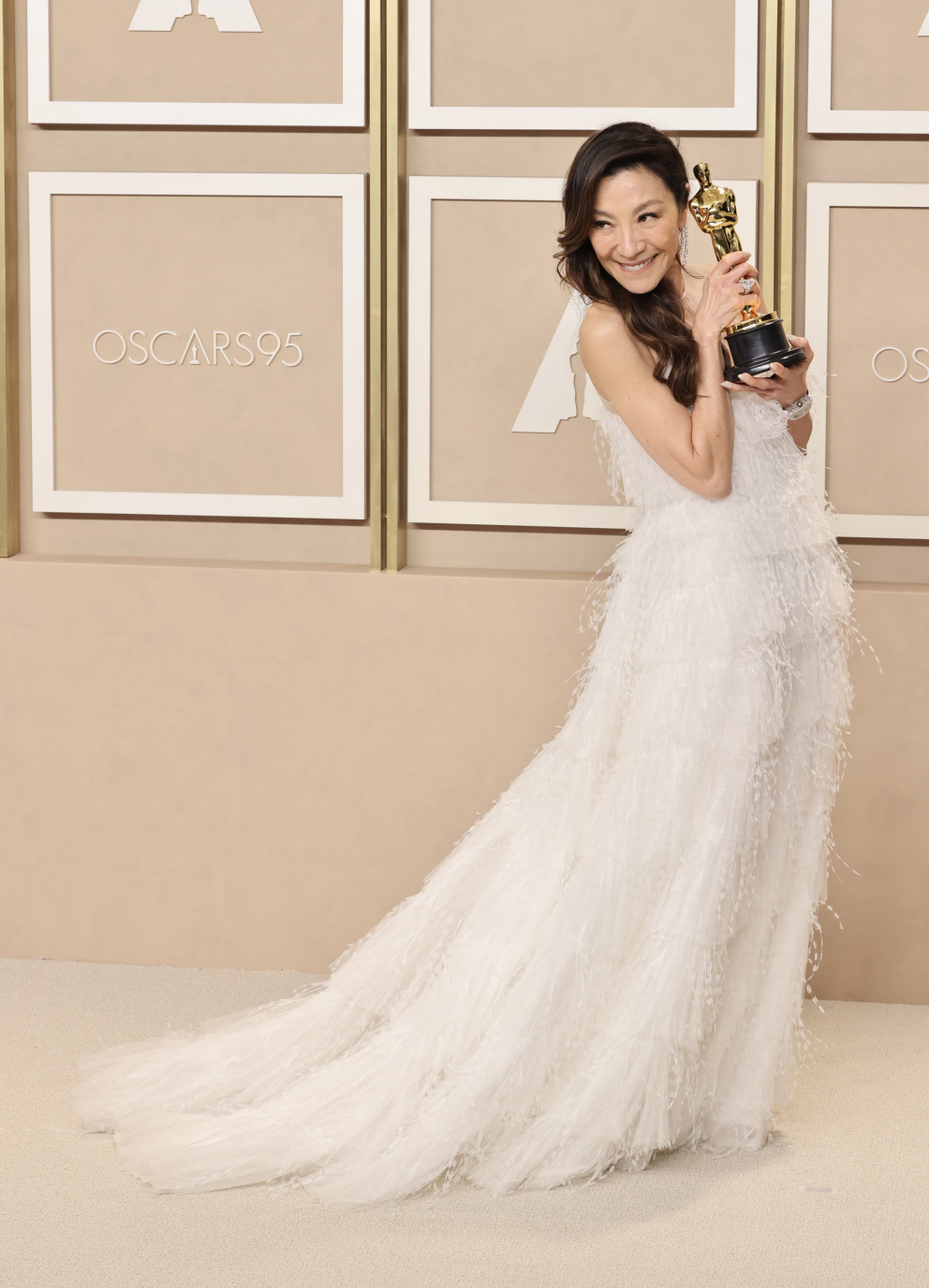 Michelle Yeoh, jež se ve světlých, éterických šatech Dior následně radovala z Oscara