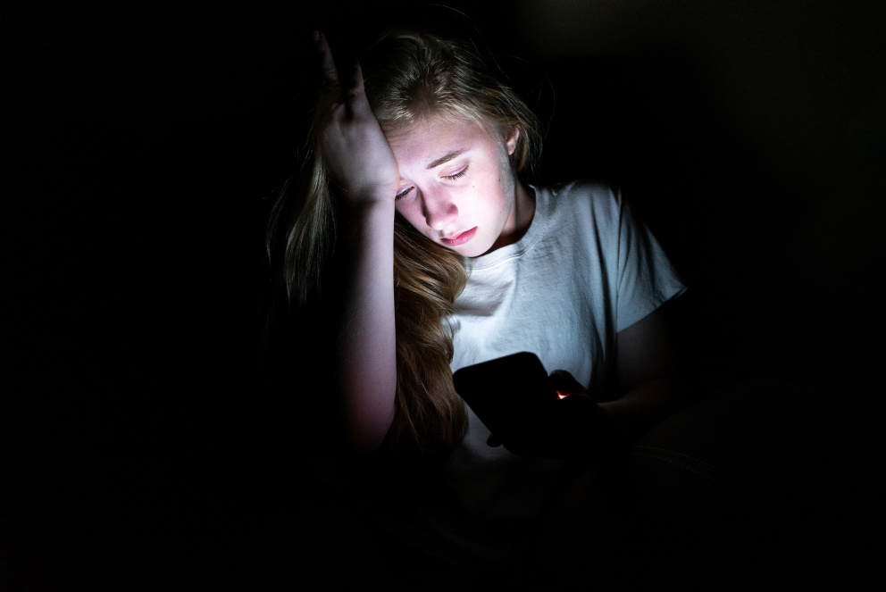 Dívka ve tmě s mobilem