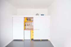 &lt;p&gt;Kuchyně se dá otevřít do obou stran,&amp;nbsp;vlevo jsou hluboké úložné boxy a knihovnička (ta je přístupná z prostoru za kuchyní, kde má majitel ložnici).&lt;/p&gt;
