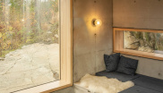 &lt;p&gt;Surový beton krásně navazuje na skálu, na které je chata postavena. Útulnost a teplo dodávají interiéru přírodní materiály, jako dřevo a kožešiny.&lt;/p&gt;
