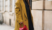Estelle Chemouny zkombinovala černý outfit s kabátem v hrachové barvě a kontrastní červenou kabelkou značky Alaïa